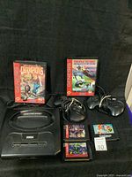 Sega Genesis console with two controllers and five game cartridges and two original game boxes for Triple Score Soccer and NFL Football Champions.
