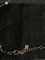 Close-up of the necklace clasp and chain stamp showing '925' mark for sterling silver.