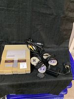 Photo showing the Super Nintendo Entertainment System console with attached cassette slot cover and two original wired controllers, AV cable, and power adapter