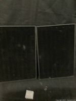 Two black velvet rectangular holders side by side on a flat surface