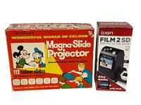 Photo of the Disney Magna-Slide Projector box next to the Ion Film 2 SD Film and Slide Scanner box, showing colorful packaging and branding.