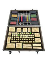 Top view of open metal case showing colored ink pads and ink bottles in upper tray, and wooden design stamps in lower tray