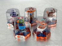 Five Hex Bug collectible figures in original clear hexagonal plastic packaging displayed together showing characters and bases.