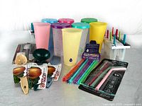Wide group shot showing all tumblers, straws, utensils, and popsicle trays.