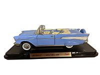 Side view of light blue 1957 Chevrolet Bel Air diecast convertible on black display base with plaque.