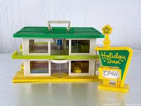 Front view of the two-story Holiday Inn building with green roof and sign placed beside it