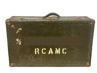 Front view of green military trunk with RCAMC markings and personalized data blurred.