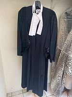 Full view of black barrister robe hanging on hanger