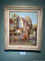 Full view of the framed oil painting showing houses, trees, and water with artist signature Toom.