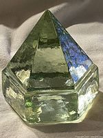 Clear image of the light green glass prism pyramid paperweight showing its shape and color.