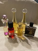 Front view of six perfume and cologne bottles, showing details of shape and color