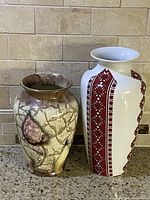 Two vases on a kitchen counter, one with red traditional pattern and one with marbled abstract design