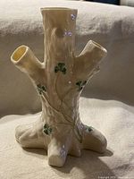 Front view of tree stump vase showing the shamrock motifs and three openings