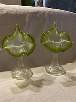 Pair of green and clear art glass vases with jack in the pulpit flower shaped tops and twisted stems.