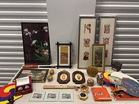 Overview of entire lot including framed art, plaques, decorative eggs, fans, metal balls, and wooden items.