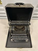 Full view of the Deluxe Leader Underwood typewriter open in its carrying case showing keyboard and platen.