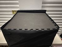 Top view of stacked foam mats with visible textured surface and black covering on sides