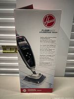 Front side of the Hoover Floormate Steamscrub Touch box showing image of the cleaner and key functions.