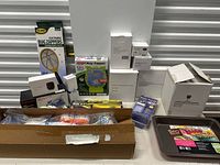 Photo showing multiple boxed household items including two electronic bug zappers, a baking pan, and various smaller boxed items.