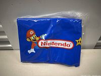 Photo of the flat packaged Nintendo Mario inflatable chair showing Mario character on blue material with Nintendo logo.