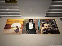 Three vinyl album covers laid side by side on a table.