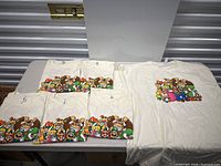 Six Nintendo character print T-shirts laid out on table, showing front design prominently.
