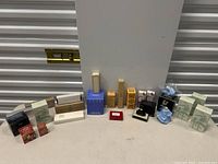 Full view of the lot showing multiple Avon perfumes and gift boxes alongside Louis Feraud cologne and ceramic figurine bottles.