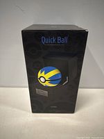 Boxed electronic replica of Pokemon Quick Ball in black display case