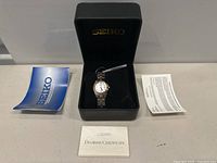 Seiko women's diamond watch in original black box, including instruction manual and diamond certificate.
