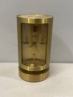 Front view of Swiza brass clock showing face with hour markers and hands
