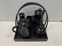 Photo of black ceramic tea set pieces on black tray with handle