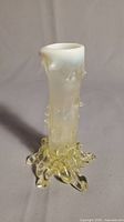 Full view of antique art glass bud vase showing tree trunk design, opalescent top rim, and pale gold base with root-like flared bottom.