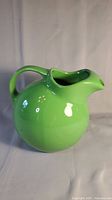 Front angle view of the vibrant green Hall Pottery jug showing the handle and spout.