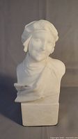 Front view of life-like carved white marble bust on square block base