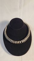 Front view of silver spiral spring choker necklace displayed on black bust stand.