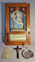 Full view of antique home altar with contents including crucifix, holy water vessel, silver dish, and booklet on a white background.