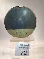 Front view of bud vase showing cobalt blue and cream matte glaze with iron speckling and notch at rim.