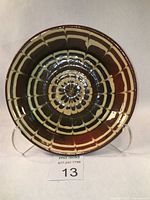 Top view photo of Ewenny Pottery slipware bowl showing concentric geometric spiderweb slip pattern with brown and cream colors on glazed ceramic.