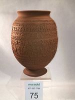 Front view of the red stoneware amphora showing textured surface and shape