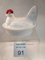 White milk glass hen on nest trinket dish with red comb, front and side views.