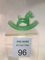 Front view of vintage jadeite green glass Scottie dog ink blotter shaped object resting on clear acrylic stand with lot label.