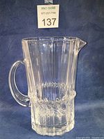 Front angle of clear glass Pallas pitcher showing handle, spout and textured midsection