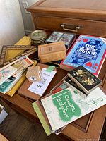 Top view of table with card decks, coasters, cribbage boards, and books including 'The Joy of Bridge'