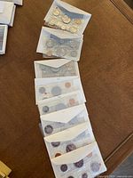 Eight sets of Canadian coins in protective sleeves on a table.