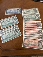 Overview of all 23 notes on table: thirteen one-dollar, nine two-dollar, one five-dollar.