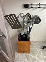 Overview of the utensil set in wooden block on kitchen counter, showing utensils and block with Cutco branding