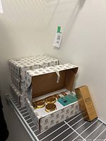 Four stacked Elizabeth Grant boxes and one Derma Roller box on wire shelf