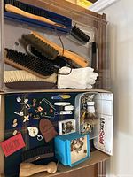 Overview of tray showing shoe brushes in upper section and assorted pins, cufflinks, compass and knife accessories in lower section