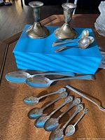 Full lot on table: candlesticks, serving spoons, sauce ladles, teaspoons and pickle fork