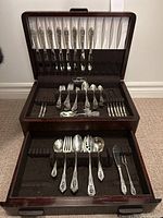 Full view of open wooden box showing two-tiered storage with flatware pieces.